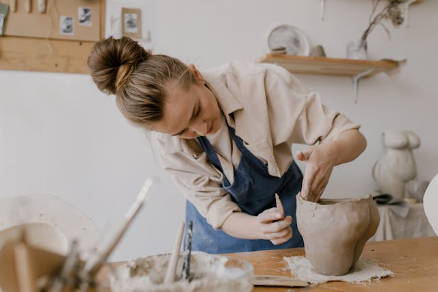 A woman making a clay vase