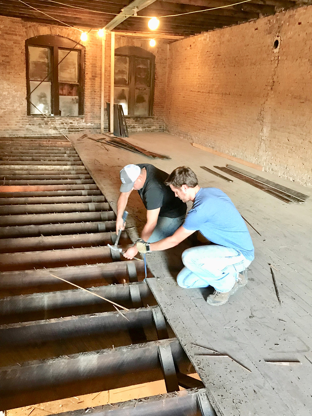 Sam Martin and Josue Rivas try to preserve the floors at the House of Vaccums, East Florence, AL Sweetwater District