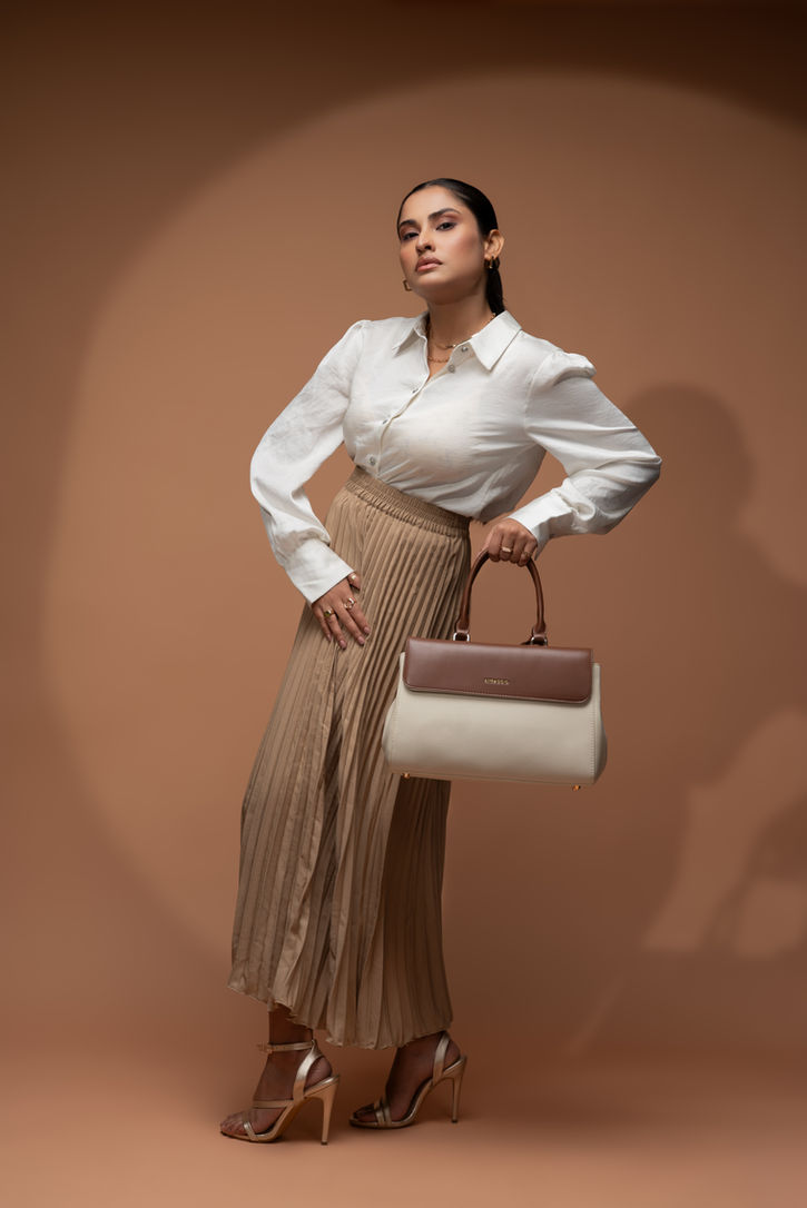 Low-angle "hero" shot of the model and Miraggio bag, creating an aspirational fashion aesthetic.