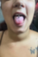 Close-up of a healed tongue piercing with titanium jewellery