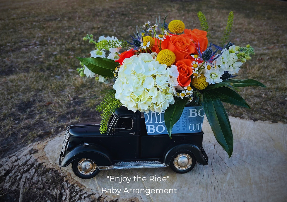 Flower arrangement in pick-up truck with tag "Enjoy the ride!" 