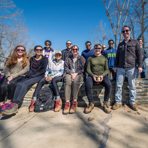 Group of hikers posing on a trail, enjoying nature and a shared adventure.