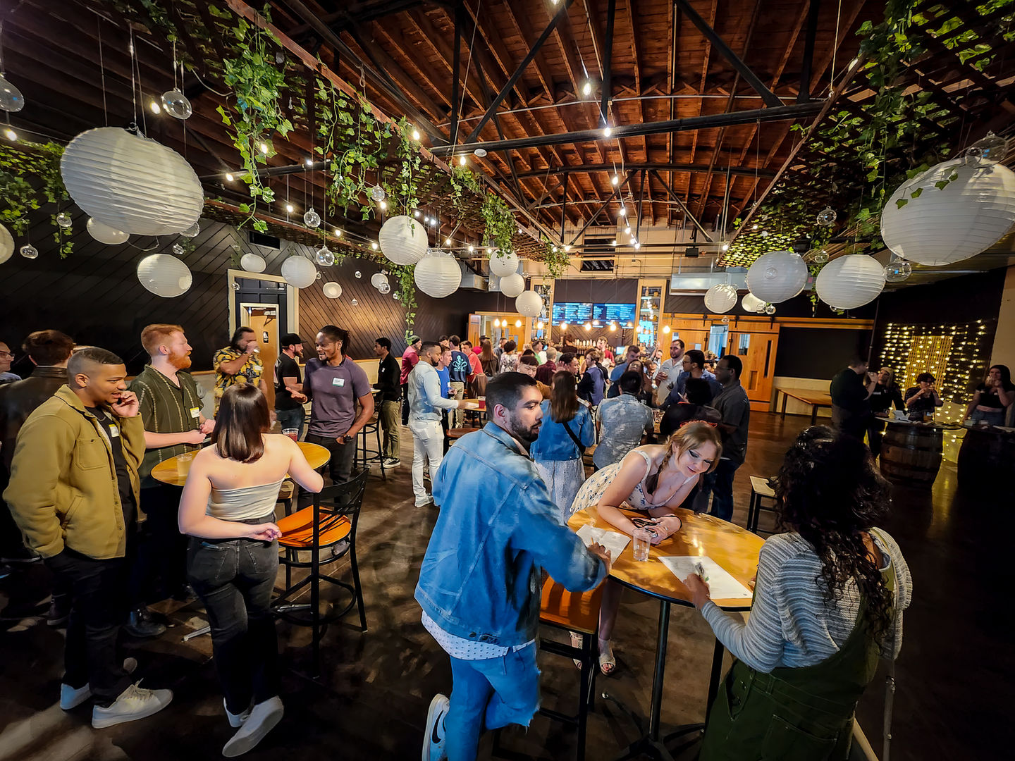 Vibrant group gathering in a beautifully decorated indoor venue with hanging lights.
