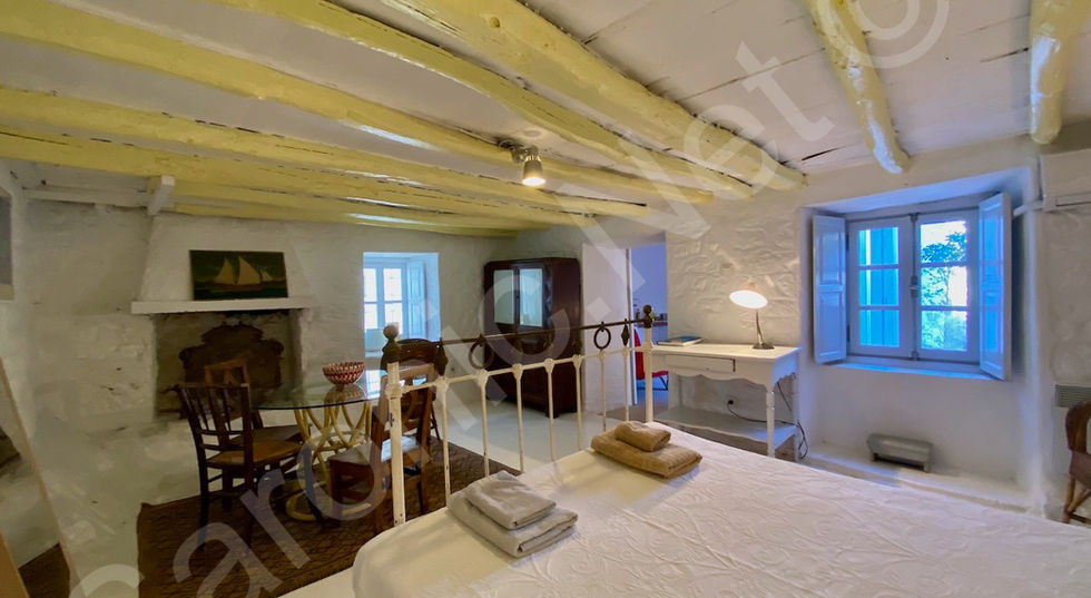 large Guest suite bedroom. dual aspect windows, fireplace and character wooden beamed ceiling