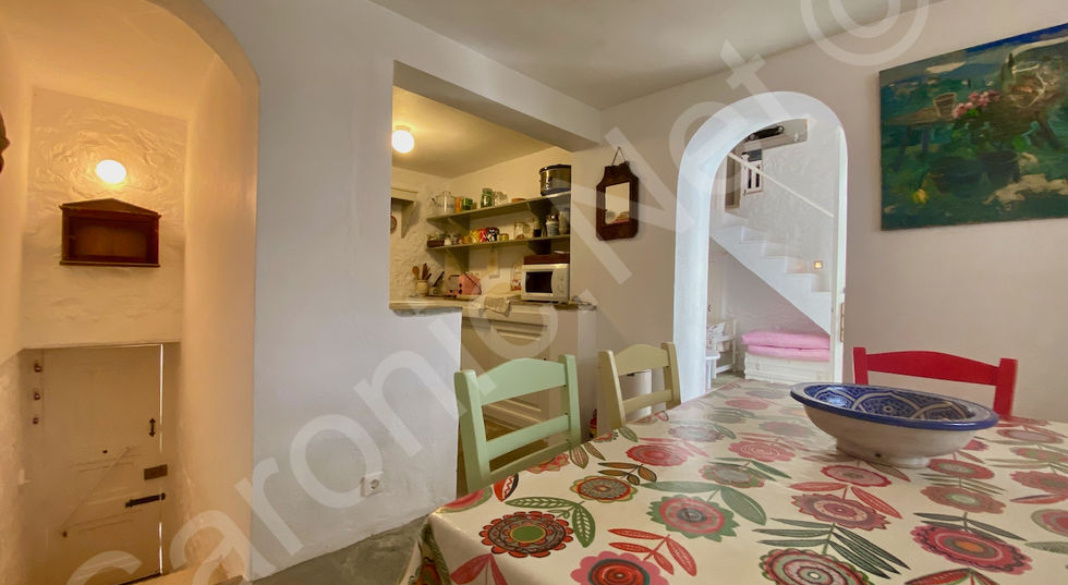 quaint dining area for building 2, kitchen opening to left and archway to sitting room