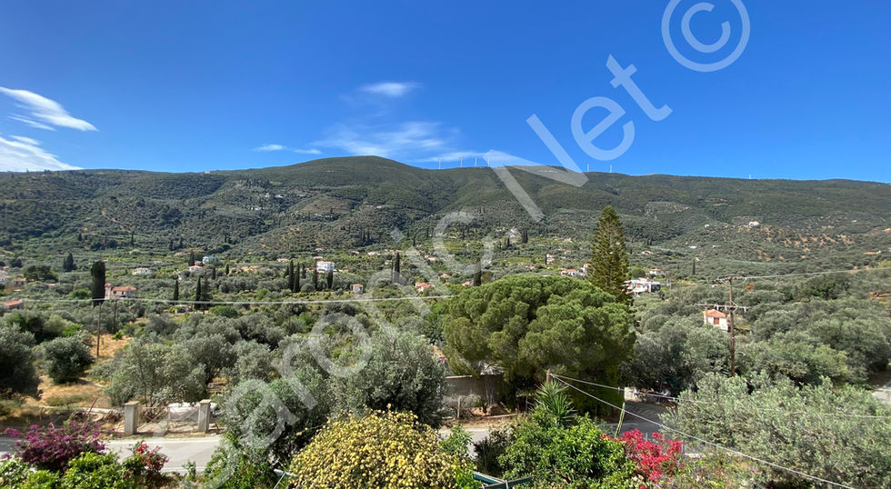 House set with extensive enclosed gardens and views across the hillside and lemon trees of Galatas