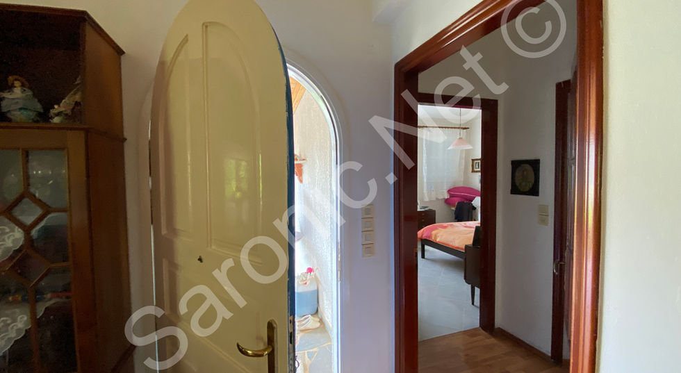 Wooden hallway looking through to the kitchen and a big arch to a bedroom