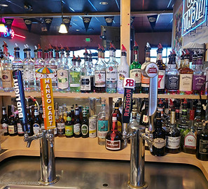 A showcase of the beer on tap and liquor at Grampy's Nevada locations, with a mirror behind the bar.