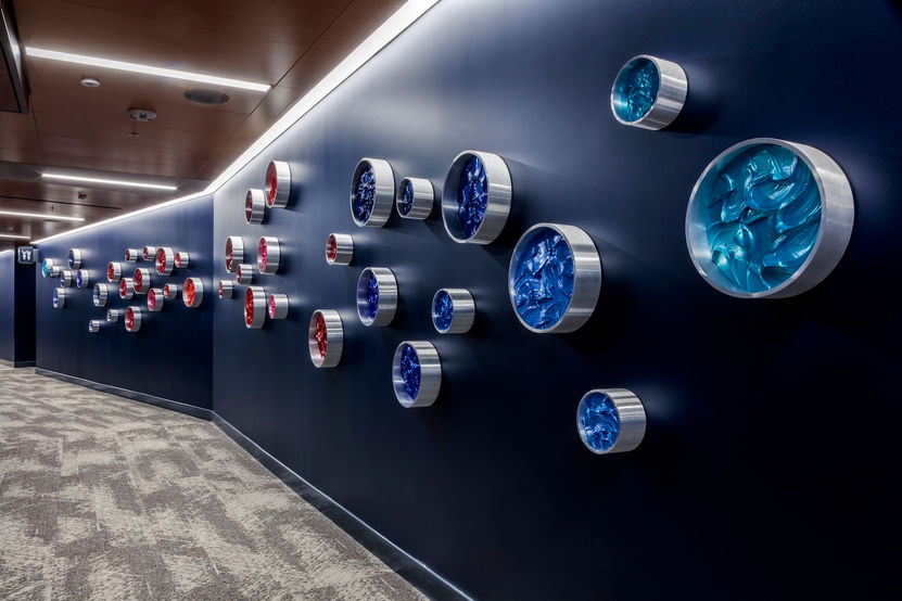 KX2 Art Intuit Dome permanent public art installation, brushed aluminum Pipeline Series wall-mounted components with blue acrylic and mixed media panels, varying sizes, corridor installation view, Intuit Dome Inglewood CA, Ruth Avra and Dana Kleinman