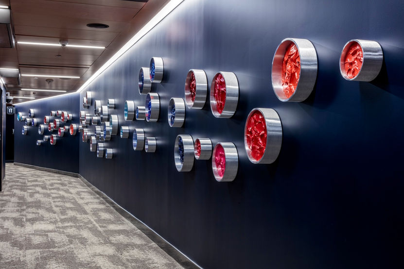 KX2 Art Intuit Dome permanent public art installation, brushed aluminum Pipeline Series wall-mounted components with red and coral acrylic mixed media panels, corridor installation view, Intuit Dome Inglewood CA, Ruth Avra and Dana Kleinman
