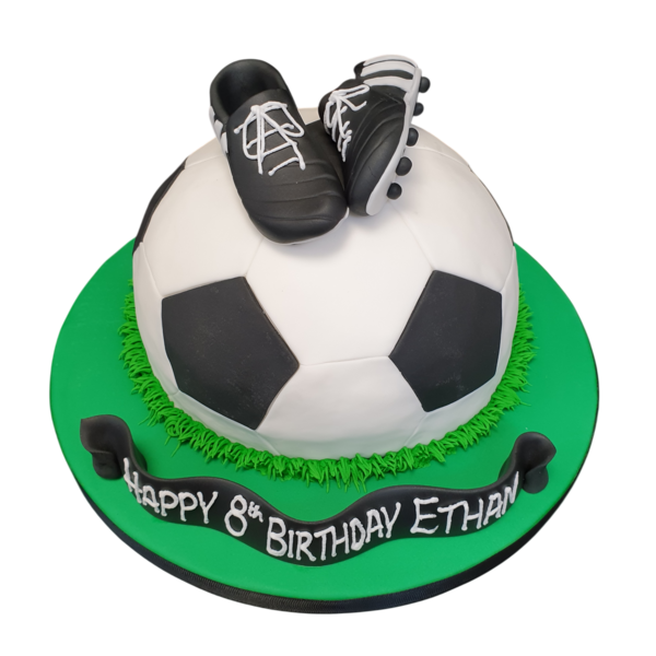 Football themed cake with realistic looking boots on top, perfect for sports fans and football enthusiasts.