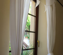 „Fenster mit weißen Vorhängen im Spielstübchen“