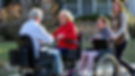 two people sitting on their power wheelchair and a woman following along on a wheelchair_e