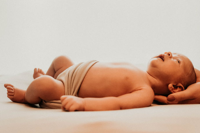 Nouveau-né couché, sur les main de sa maman.