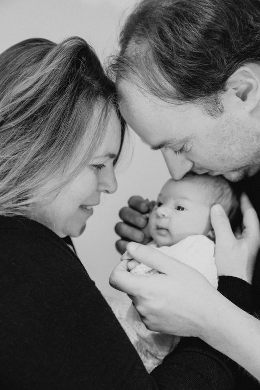 Famille avec bébé entouré des mains des parents