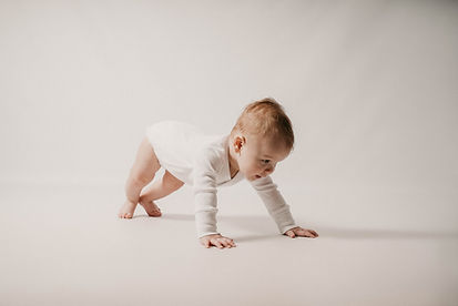 Portrait en studio d’un bébé à quatre pattes, en train d’avancer.