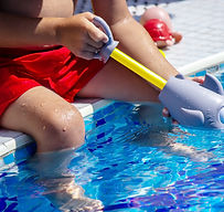 happy-child-in-the-pool-playing-with-a-water-gun-2023-11-27-04-55-00-utc.jpg