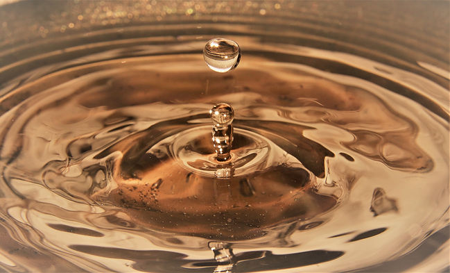 close-up-of-golden-water-droplets-splashing-2024-10-21-14-55-38-utc.jpg