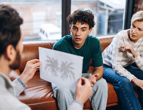 male-psychologist-holding-ink-blots-to-teenage-boy-2025-03-21-21-05-42-utc.jpg
