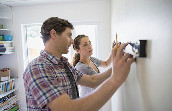 couple-using-level-tool-on-living-room-wall-2026-01-11-08-39-39-u