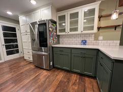 Modern kitchen with green cabinets and stainless steel fridge