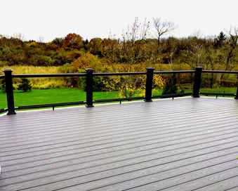 TimberTech Arbor Island Oak deck corner with curved stairway and Premier Glass Infill railing in South Barrington IL