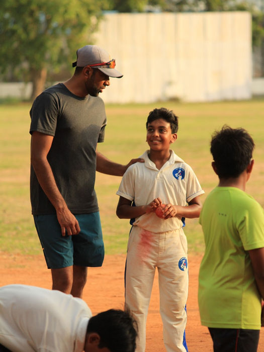 Ravichandran Ashwin giving one-on-one advice to a young cricketer, with a supportive hand on his shoulder