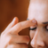 A close-up of a woman tapping gently on her face, demonstrating Emotional Freedom Techniques (EFT) for healing and self-connection.