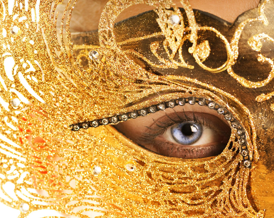 Close-up of a blue eye behind a decorative gold mask, symbolising the hidden self and emotional masking in people-pleasing