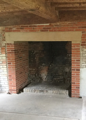 Restored brick fireplace with an oak mantle