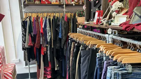 Interior of the Shop from Crisis charity shop in Camden Parkway. The shop is decorated for Christmas with Santa hats and presents on the floor.