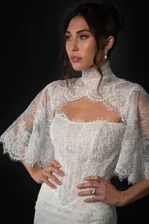 Lace fit and flare wedding dress with basque waist and pearl beading. Detachable lace bolero capelet sleeve, high neck. Two looks in one. Chantilly scalloped eyelash lace.