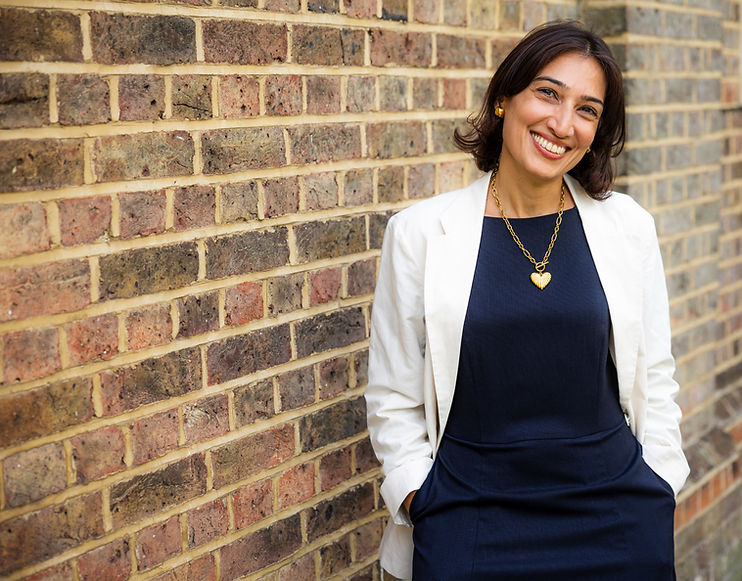 Pooja Sachdev, founder of Rewire Consulting, smiling outdoors in a navy dress and white blazer