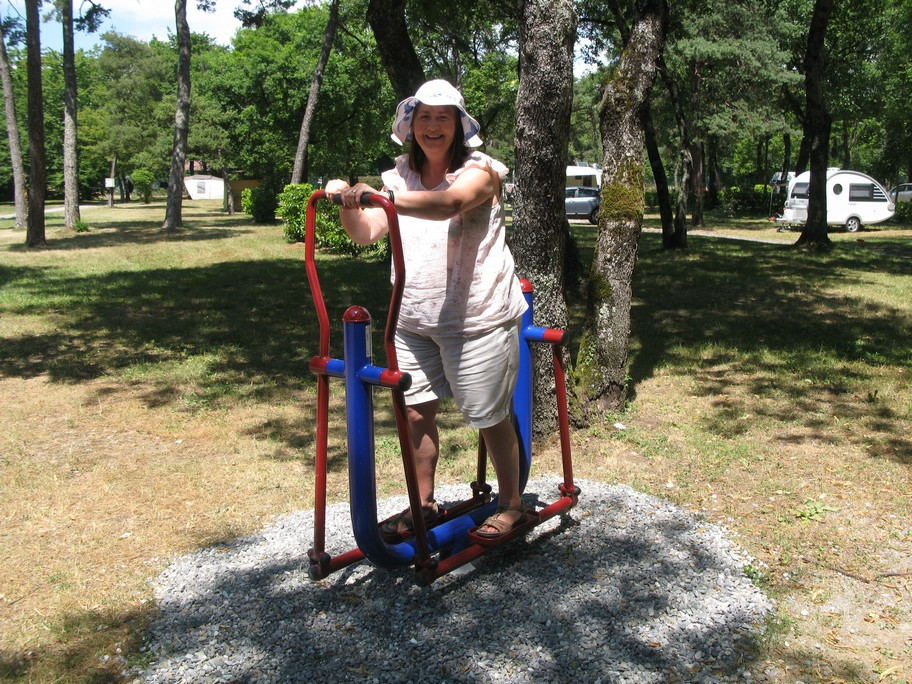 Person on outdoor exercise equipment in a park.