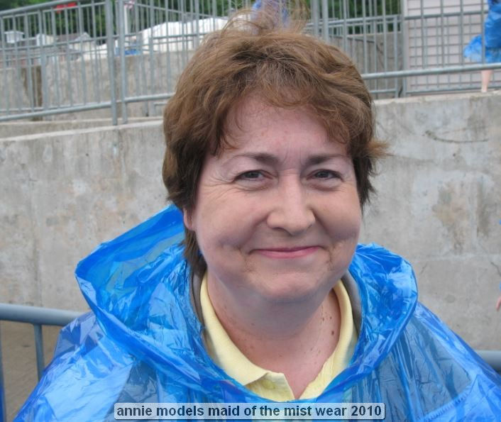 Smiling person in blue rain poncho outdoors.