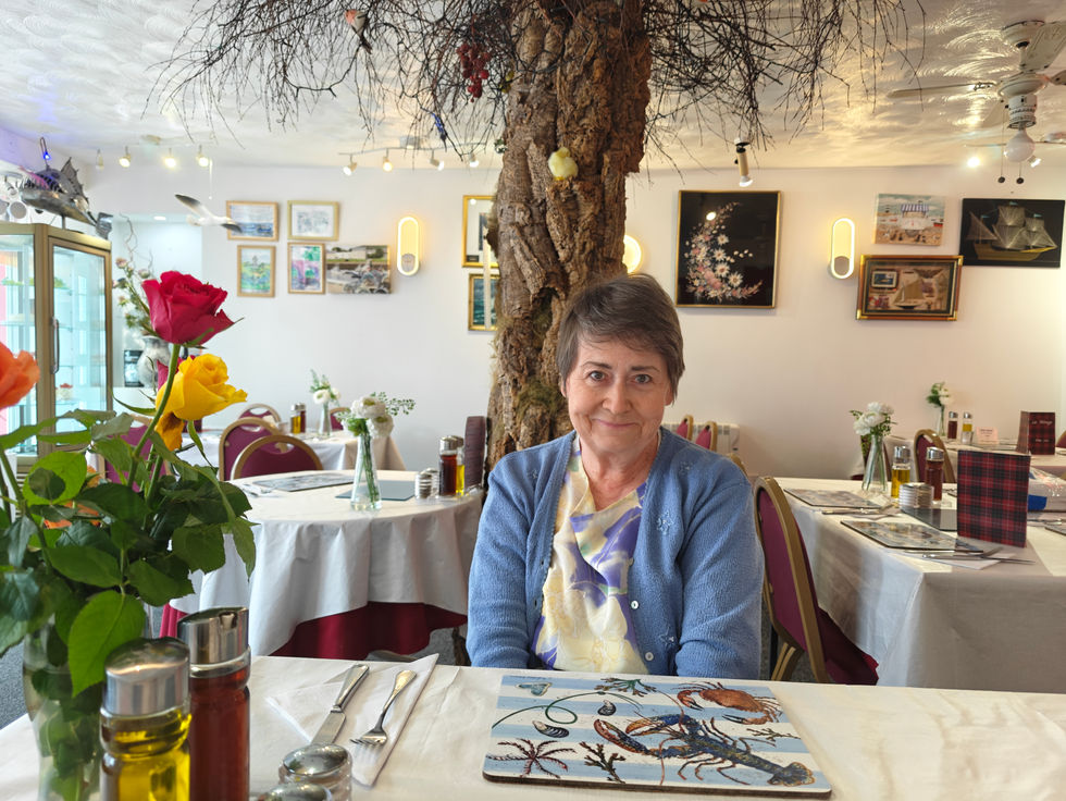 Woman sitting in a decorated restaurant.