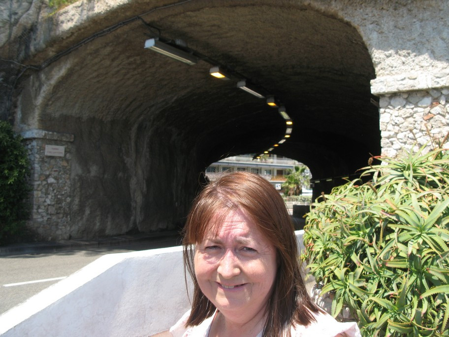 Woman standing near a tunnel entrance.