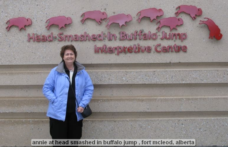 Person at Head-Smashed-In Buffalo Jump sign.