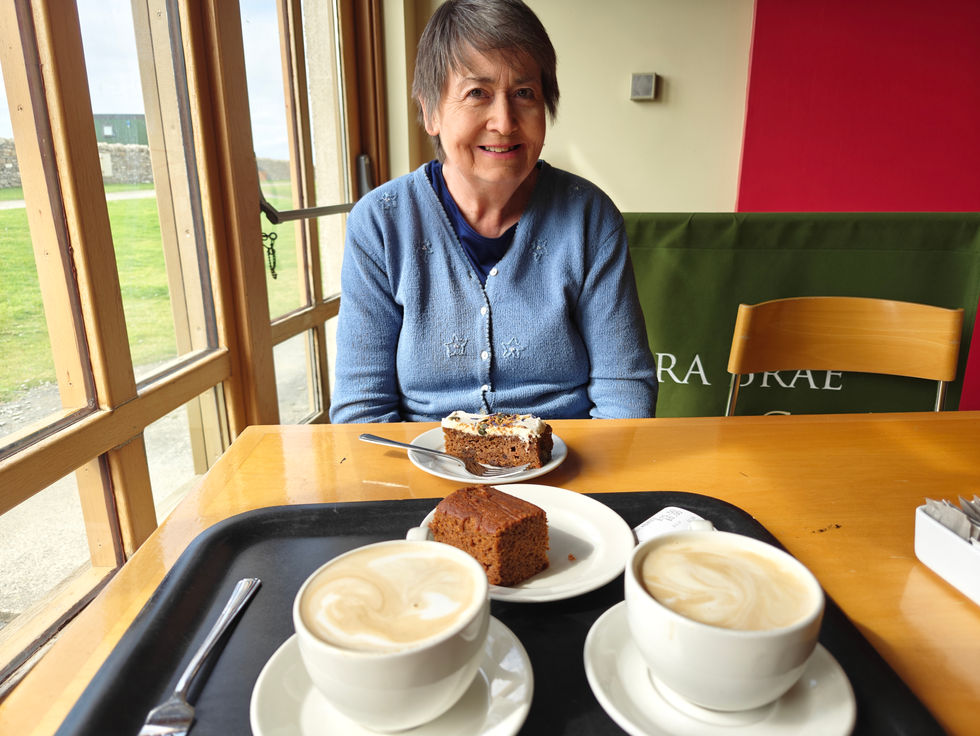 Woman enjoying coffee and cake at a café.