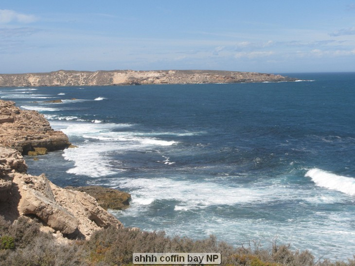 Coastal landscape with rocky cliffs and ocean waves.