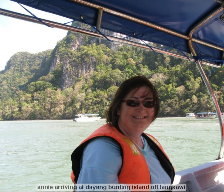 Person on boat near lush island landscape.