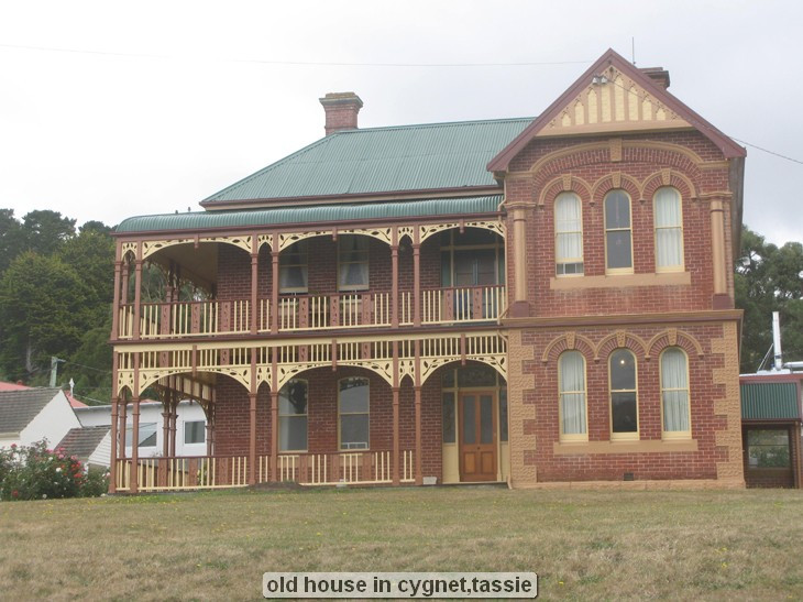 Old house with two-story veranda and arched windows.