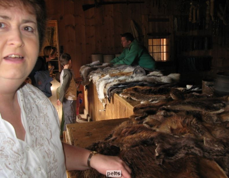 People in a rustic setting with fur displays.