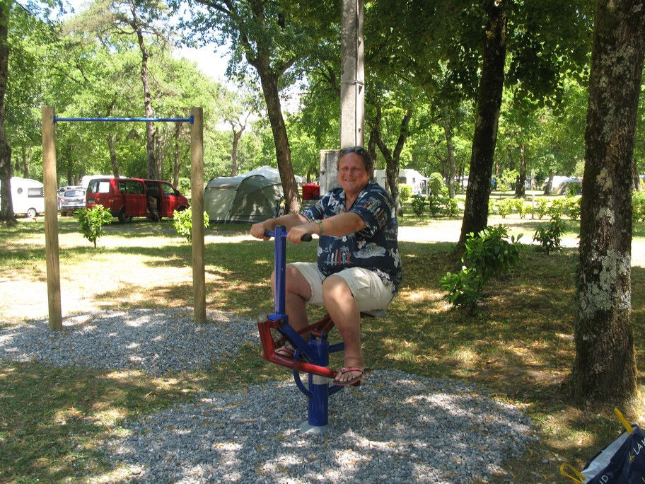 Person on outdoor exercise equipment in a park.