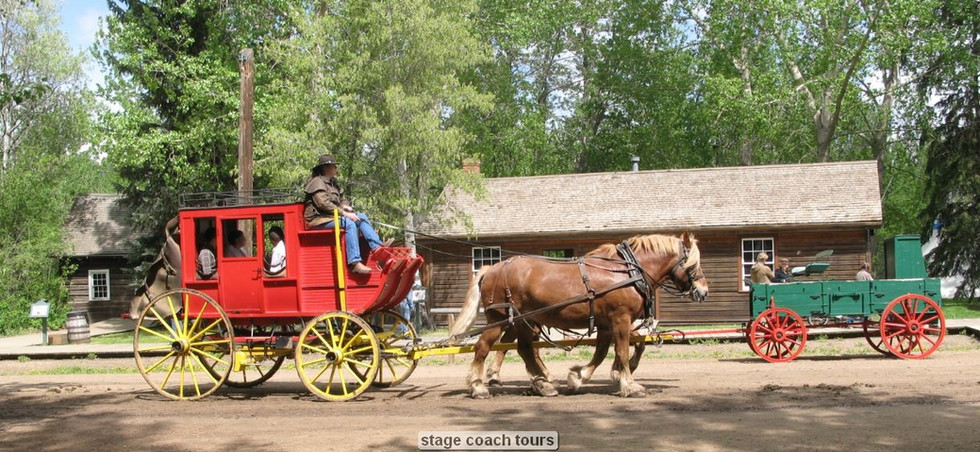 Red stagecoach pulled by two horses in rustic setting.