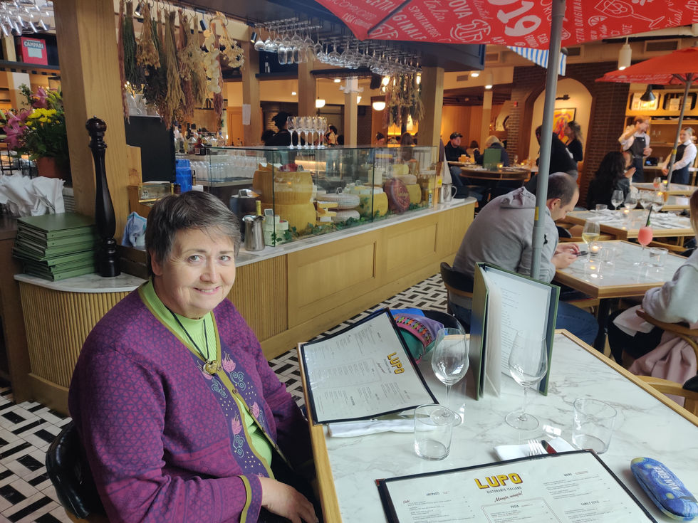 Woman sitting at a restaurant table, holding menu.