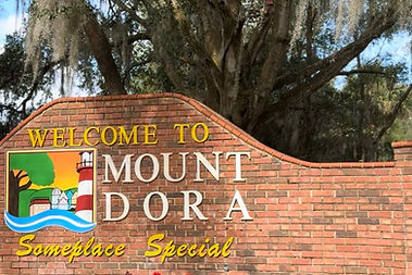 Sign of Mount Dora Florida with a brick partitian and a lighthouse on it