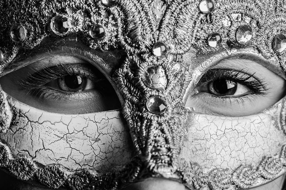 close up of a person's eyes behind a carnival mask