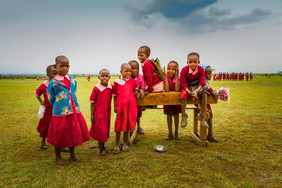 ecoliers masai en tenue traditionnelle devant un pupitre