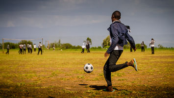 jeune garcon joue au football dans une ecole au kenya